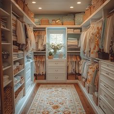 a walk in closet with lots of clothes and rugs on the floor next to it