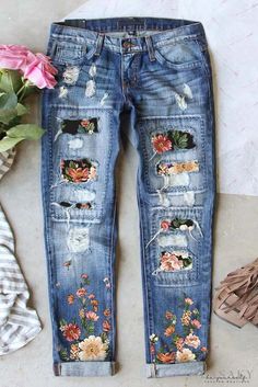 a pair of jeans with flowers painted on them