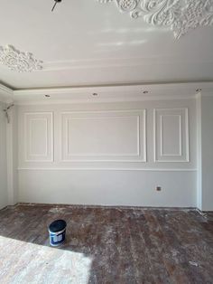 an empty room with white walls and wood flooring in the process of being painted