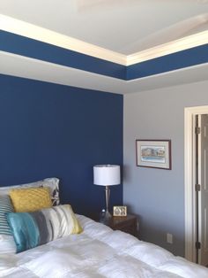 a bedroom with blue walls and white bedding