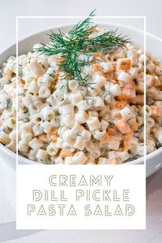 creamy dill pickle pasta salad in a white bowl with a green sprig on top