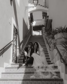 a bride and groom are sitting on the stairs at their wedding ceremony in santa monica, california