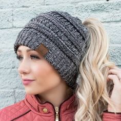 a woman with blonde hair wearing a knitted beanie and looking off to the side