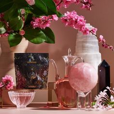 pink flowers in vases and other items on a table