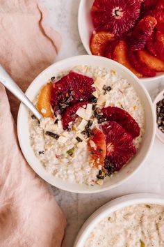 two bowls of oatmeal with fruit and nuts on the side, one bowl has blood oranges