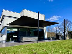 the outside of a modern building with grass and trees