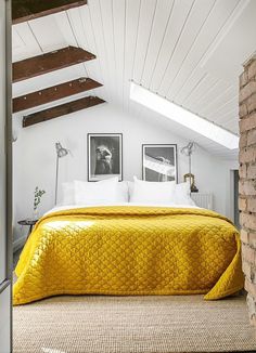 a bedroom with white walls and yellow bedspread