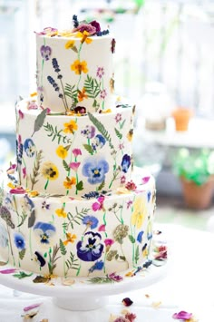 a multi - tiered cake with colorful flowers on it