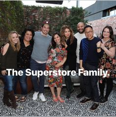 a group of people standing next to each other in front of a brick wall with the words, the superstarstore family