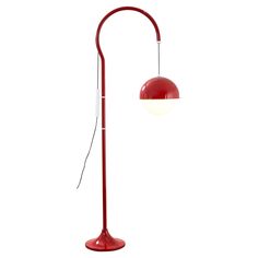 a red floor lamp with a white light on it