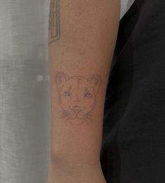 a woman's arm with a tattoo of a tiger on it, and an arrow in the background