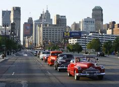 several classic cars are lined up on the street