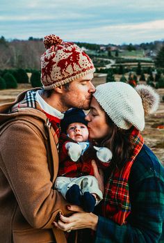 a man and woman kissing while holding a baby in front of an instagram page