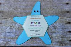 a starfish shaped birthday party card on a wooden table