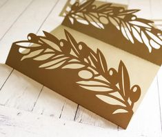 two pieces of paper cut out to look like leaves and branches on white wood flooring