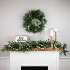 a mantel decorated with greenery and christmas wreaths