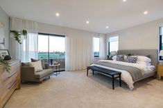 a bedroom with a large bed sitting next to a window filled with lots of windows