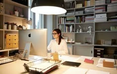 a woman sitting at a desk in front of a computer