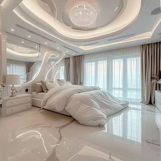 a large white bed sitting in the middle of a bedroom next to a tall window