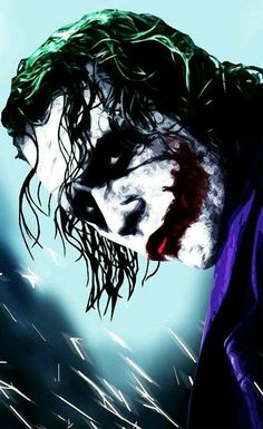 the joker with green hair is looking down at something in the air and has his face painted red