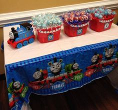 thomas the tank engine birthday cake and cupcakes on a train themed tablecloth