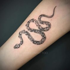 a black and white snake tattoo on the arm