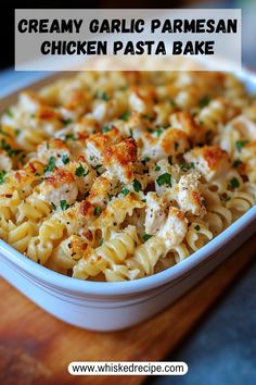 creamy garlic parmesan chicken pasta bake in a white dish on a wooden cutting board