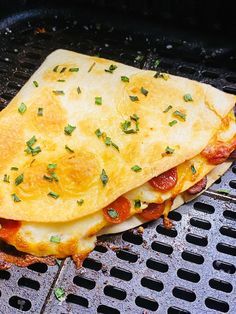 an omelet is sitting on top of the grill with some parmesan cheese