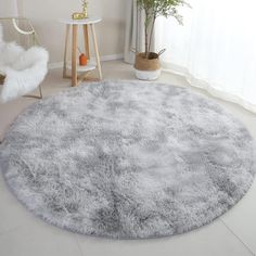 a large round rug in the middle of a living room with white walls and flooring