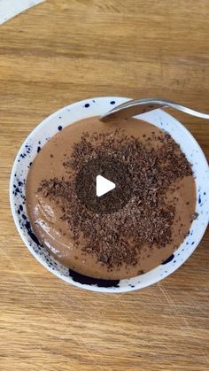 a bowl filled with chocolate pudding on top of a wooden table