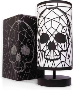 a black and white lamp with a skull on it next to a box that has an image of a skull on it