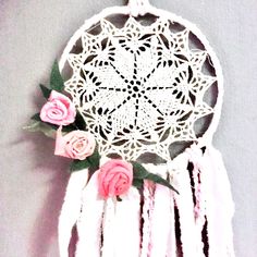 a white dream catcher with pink roses on it