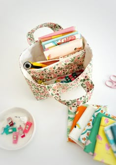 a bunch of crafting supplies sitting on top of a white table next to some scissors