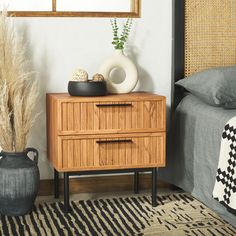 a wooden dresser sitting next to a bed on top of a black and white rug