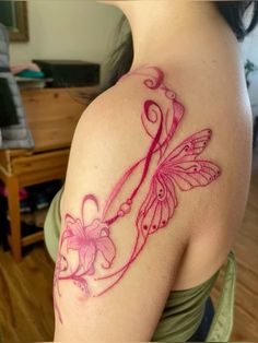 a woman with a tattoo on her shoulder holding a pair of scissors and pink flowers