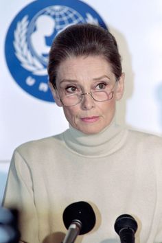 an older woman wearing glasses at a press conference