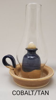 a blue vase sitting on top of a wooden tray next to a glass carafe