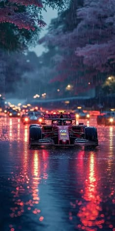 a race car driving through the rain on a rainy day with lights reflecting in the water