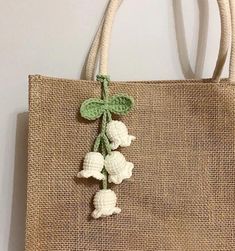 a handbag with crocheted flowers hanging from it