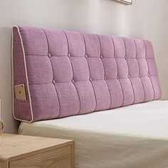 a pink headboard on top of a bed in a bedroom