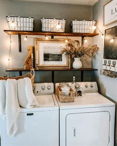 a washer and dryer in a small room with lights on the wall above them