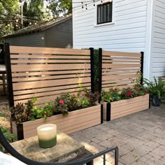 two wooden planters with flowers in them on a patio