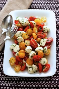 a white plate topped with tomatoes and mozzarella