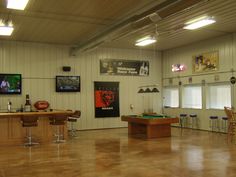 an indoor pool table and bar in a room with wood floors, white walls and ceiling