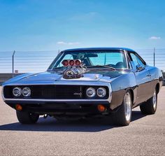 an old muscle car parked in a parking lot