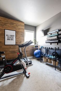 there is a bike and exercise equipment in this home gym room with wood paneling