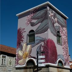 a large building with flowers painted on it's side and windows in the front