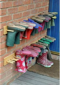 several pairs of shoes are lined up against a brick wall on the outside of a building