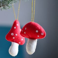 two red and white mushrooms hanging from a christmas tree