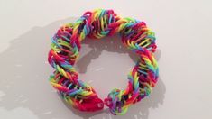 a colorful bracelet is shown on a white surface with shadow from the object behind it